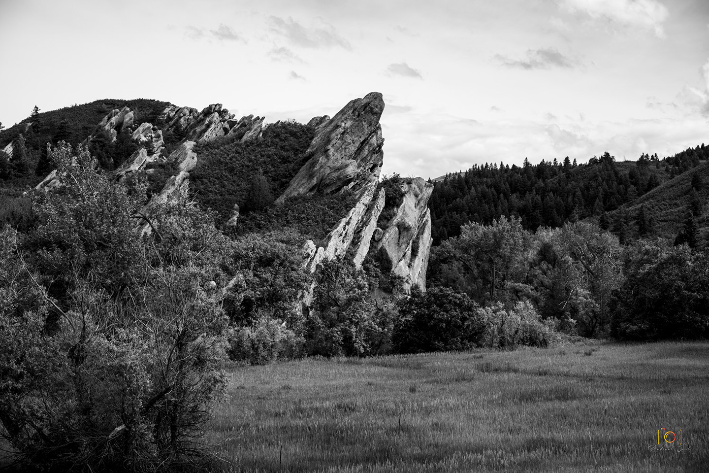 Black and White photograph of a red rock pointing towards the sky at Roxbrough Park