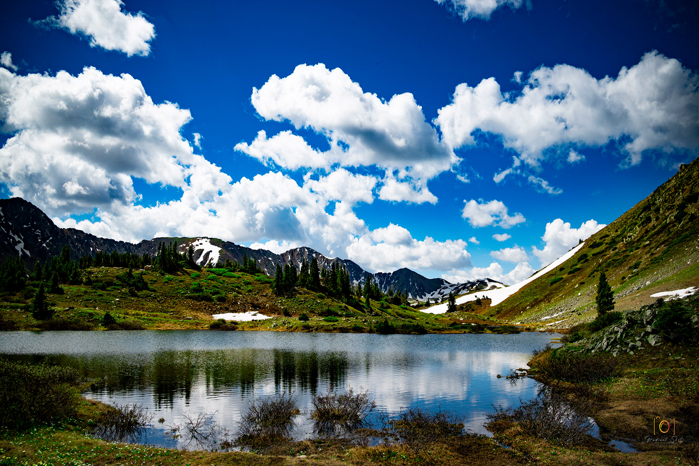 Color photograph of a high alpine lake on Loveland Pass with mountains in the background