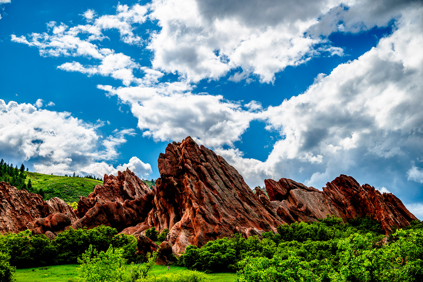 Color photograph of a red rock formation pointing towards the sky at Roxbrough Park